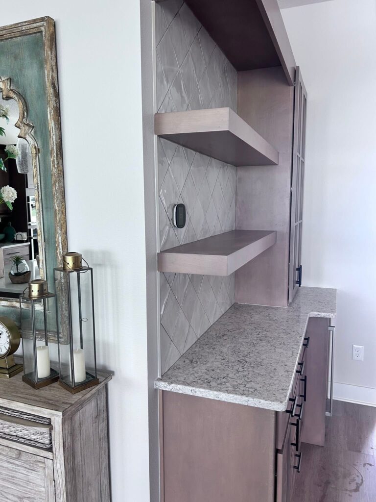 Clean lines and seamless custom-cut tile work around floating shelves create a highly functional, beautiful coffee station.