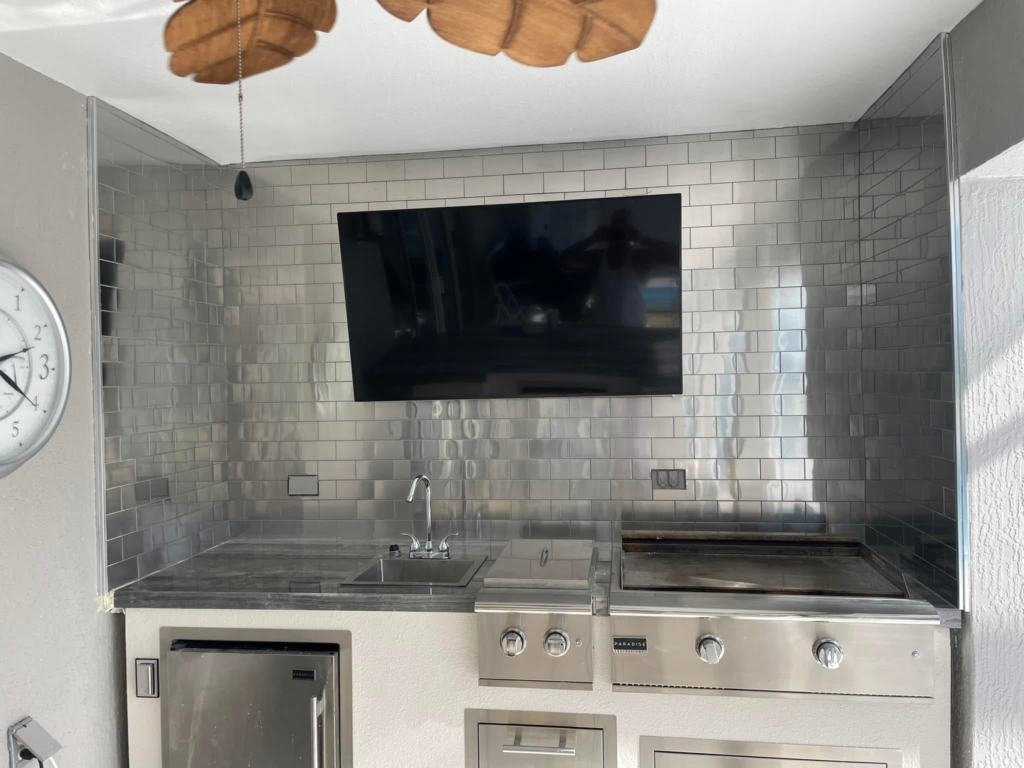 High-gloss reflective tilework takes this indoor-outdoor grill station and bar area to the next level of modern luxury entertainment.
