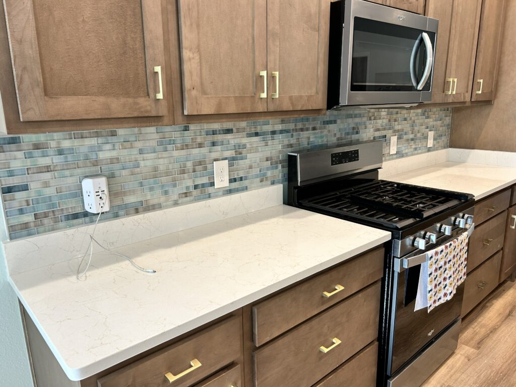 Detailed glass mosaic backsplash installation showcasing high-quality tile craftsmanship.