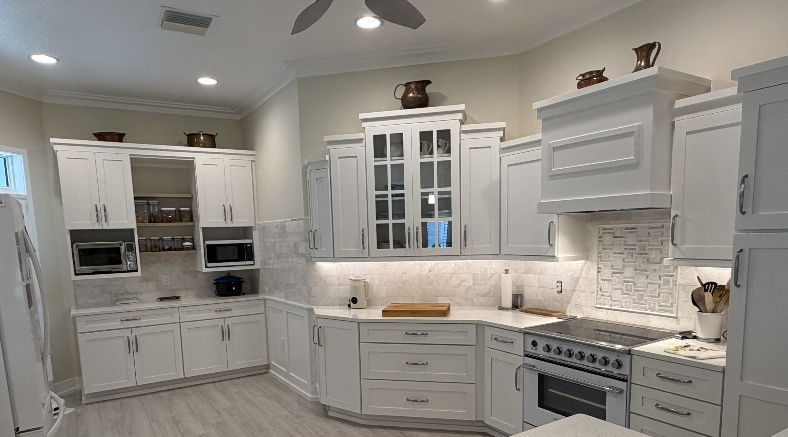 Full kitchen remodel featuring a natural stone subway tile backsplash with under-cabinet lighting by CRB Services Pro.