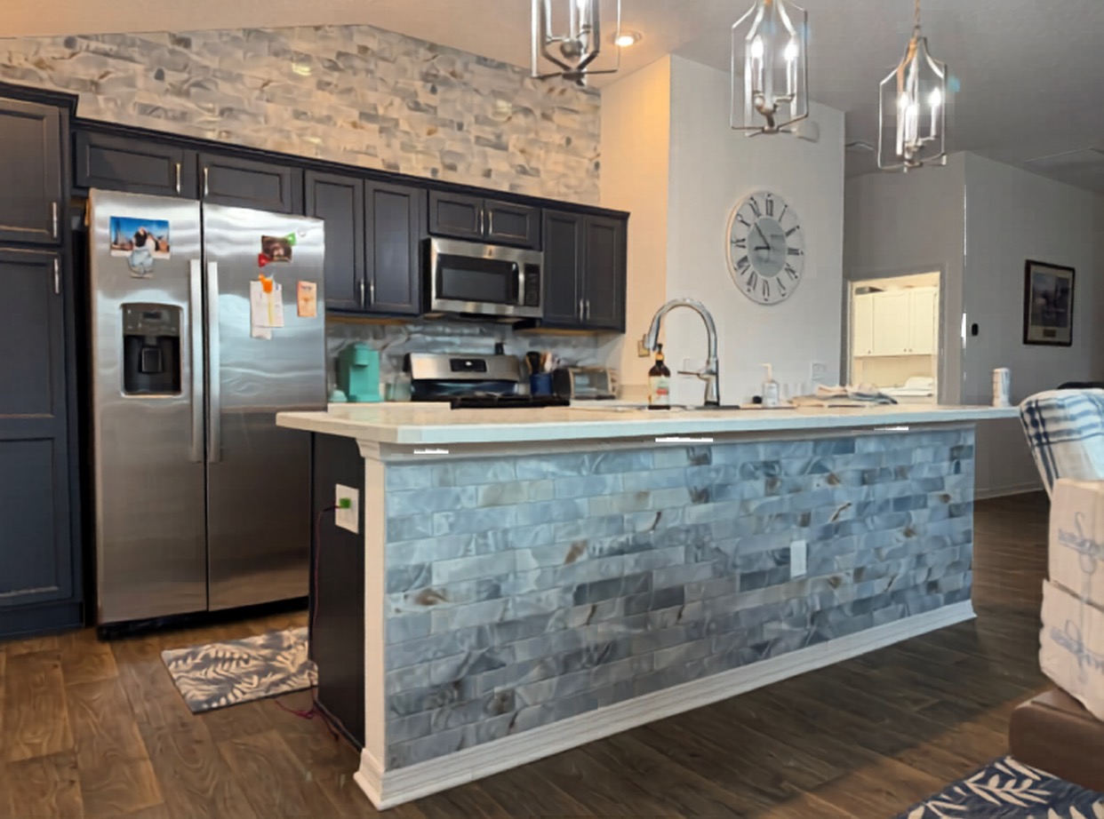 Unique floor-to-counter tile wrap on a kitchen island featuring multi-tonal stone-look planks and a matching backsplash by CRB Services Pro.