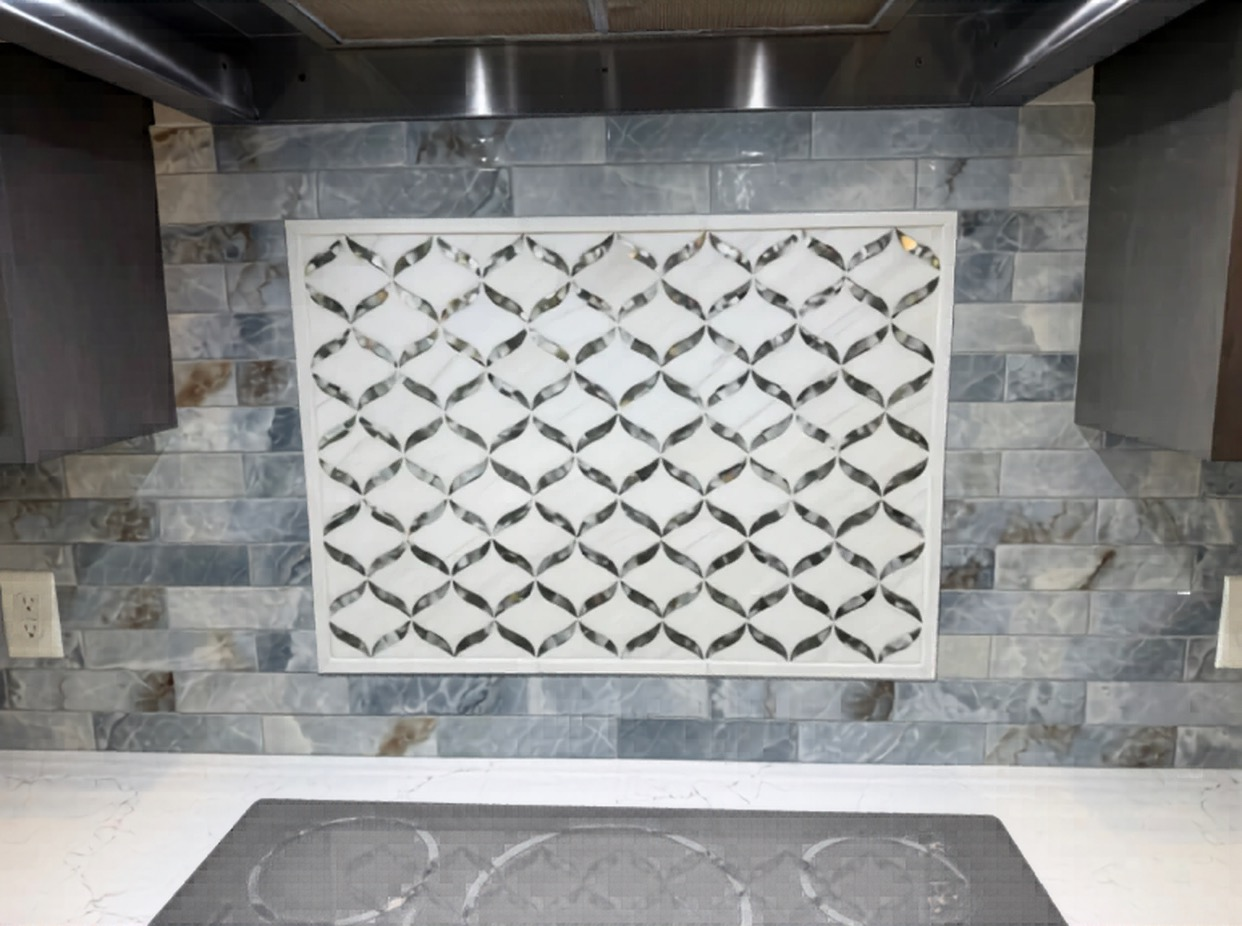 Custom kitchen tile installation featuring a decorative geometric mosaic focal point over the range.