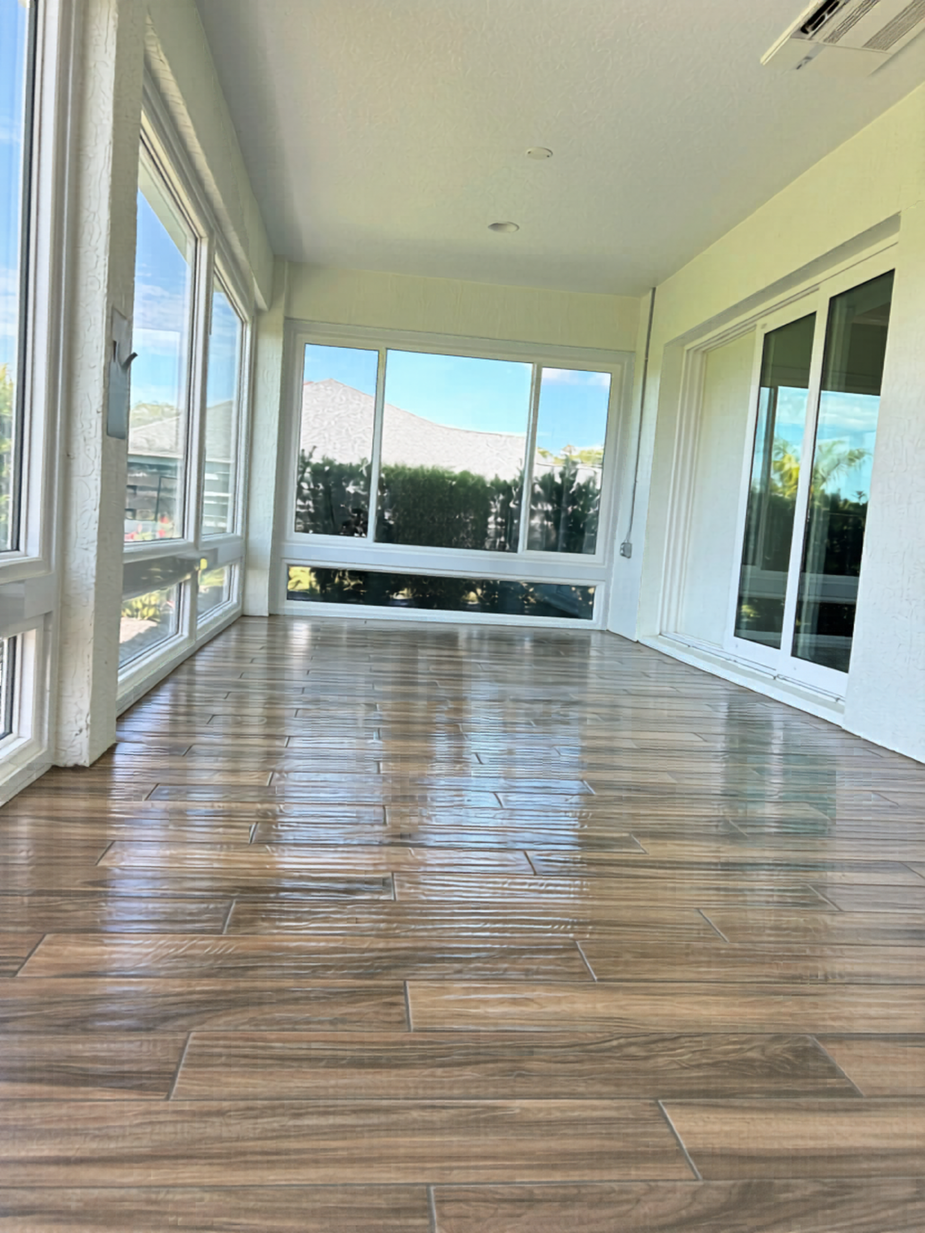 Elegant walnut-toned glazed porcelain tile installation creates a stunning, light-reflective showroom finish for this enclosed room.