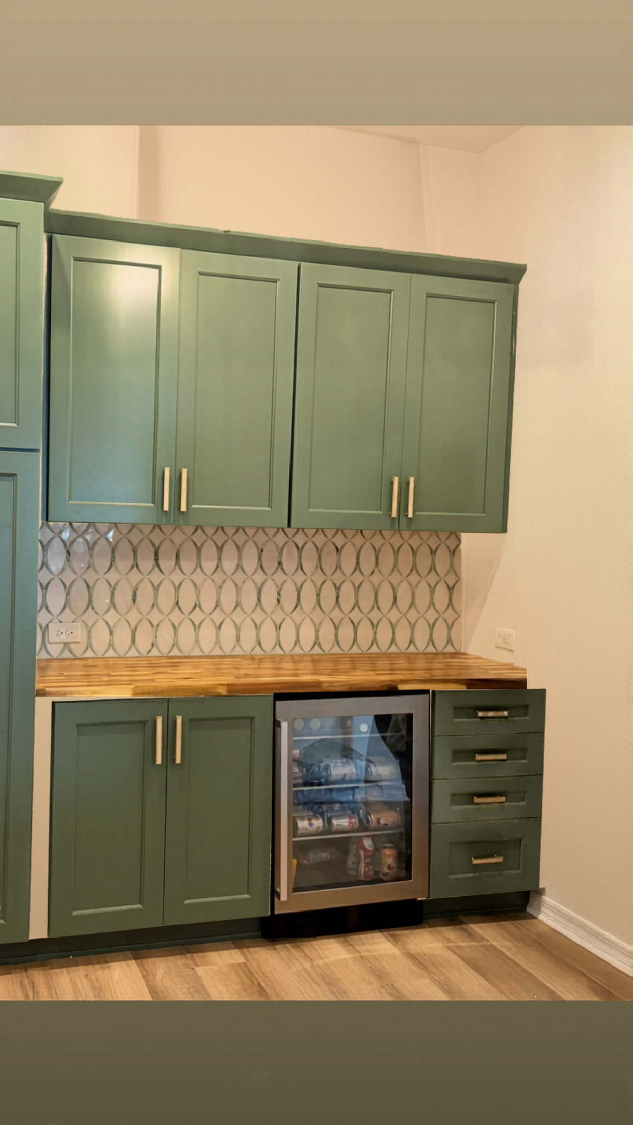 Elegant white textured kitchen backsplash paired with custom sage green cabinetry in The Villages, FL.