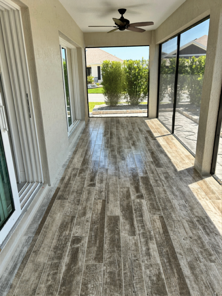 Modern screened-in lanai with custom gray tile flooring.