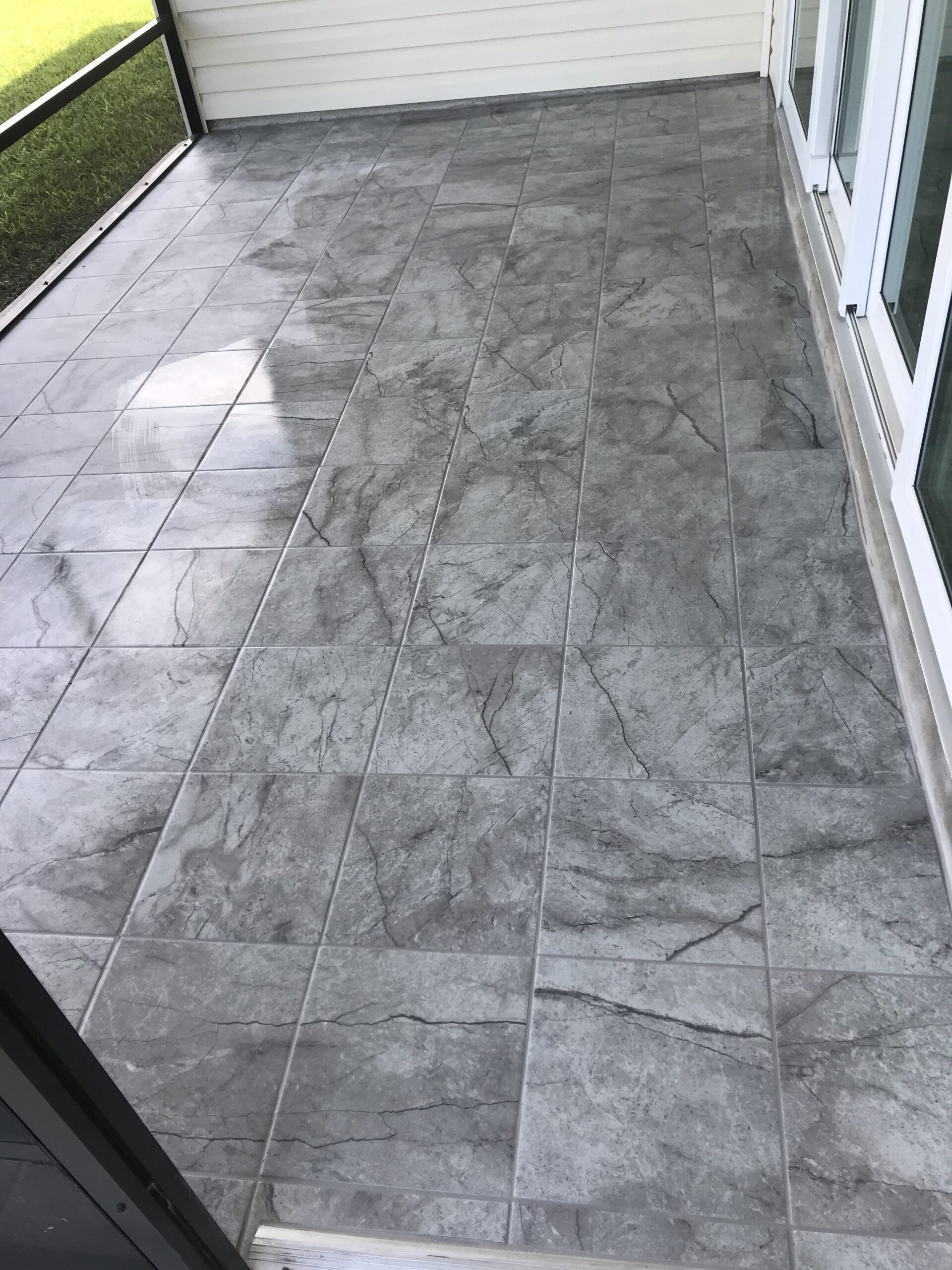The rich veining and realistic stone appearance of this porcelain tile bring timeless elegance to this outdoor space. Careful layout and consistent grout lines create a polished finish that complements the home's architecture and surrounding landscape.