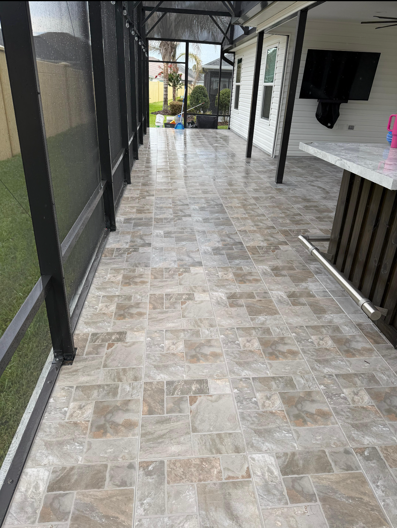 Complete Outdoor Living Space
Built to withstand Florida's weather, this porcelain tile floor combines lasting durability with timeless style. The multi-tone stone appearance adds depth and character while creating an elegant foundation for this expansive screened lanai.