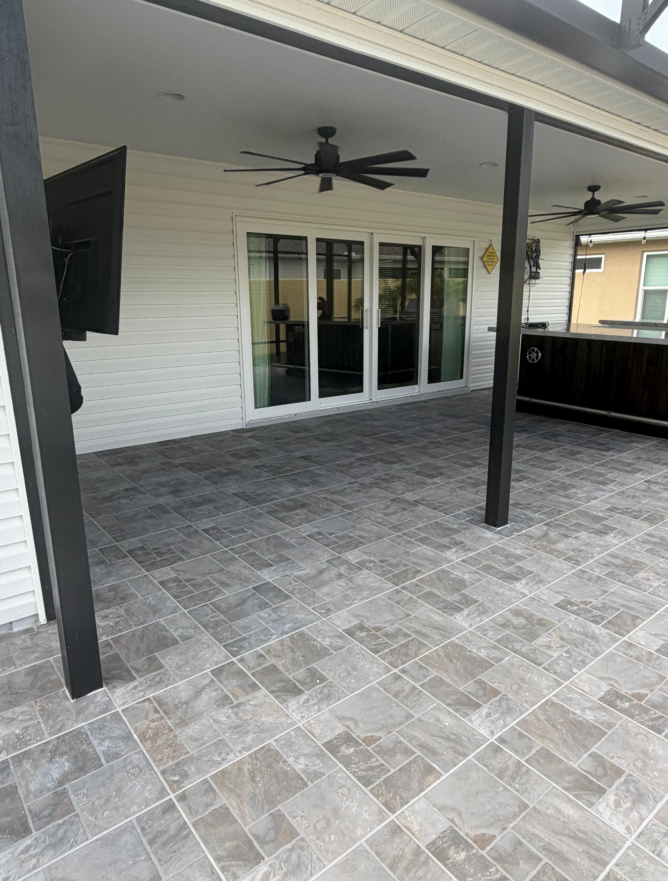 Complete Outdoor Living Space
Every tile was carefully installed with consistent spacing, clean grout lines, and precise cuts around support columns and walls. The result is a seamless, professional finish that enhances both the beauty and functionality of this outdoor entertainment space.